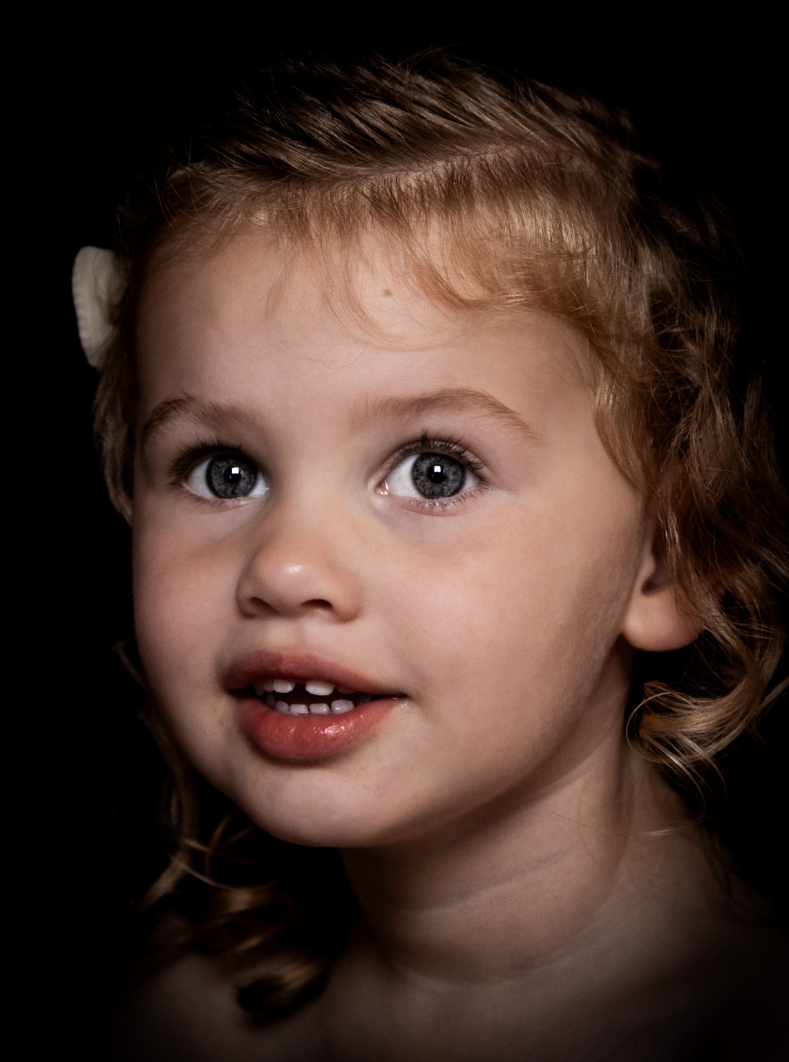 Fine art kinderportret van een meisje dat omhoog kijkt