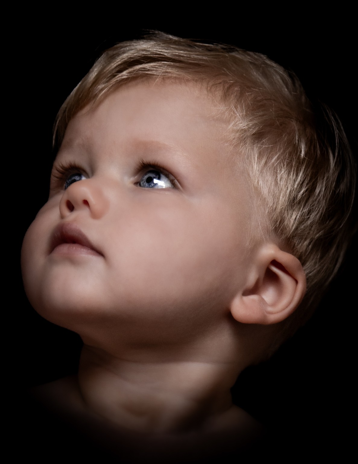 Fine art kinderportret van een jongetje dat omhoog kijkt